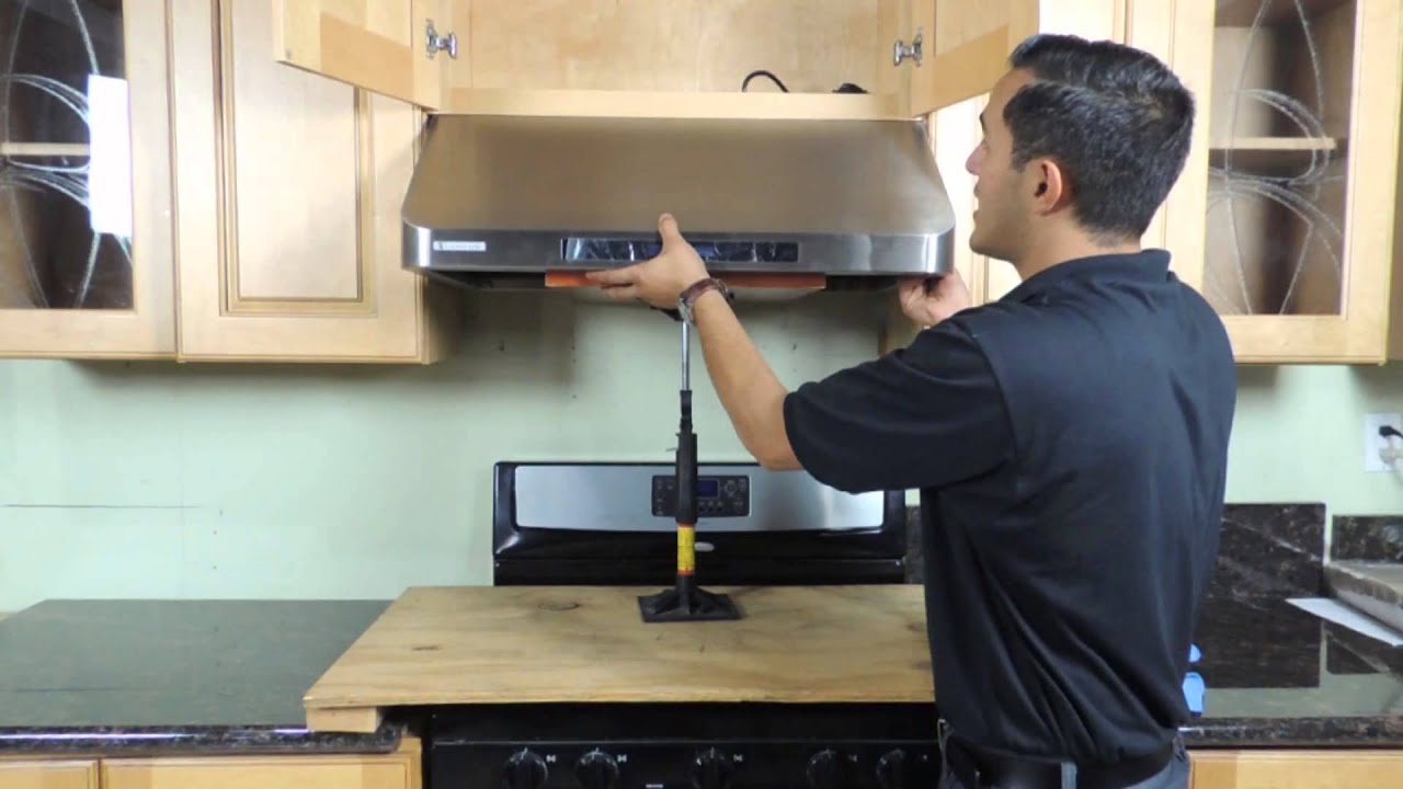 Kitchen hood installer working on commercial extraction system in Peterborough